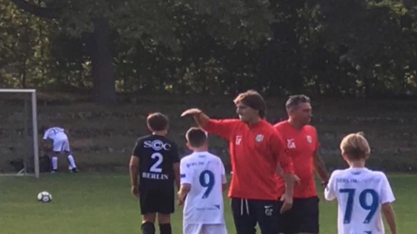 Entrenador dirigiendo una sesión de fútbol juvenil en Berlín